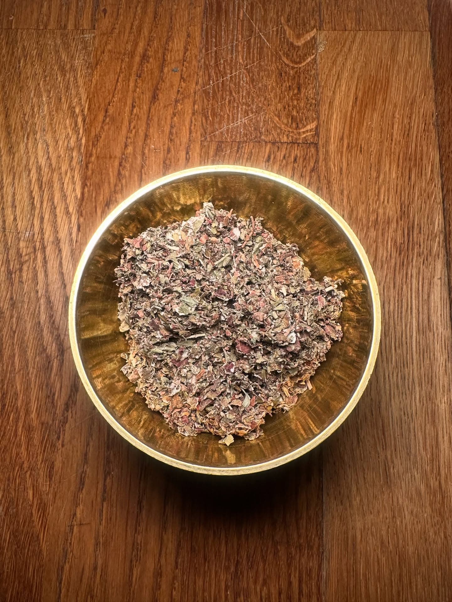 Dried herbs in traditional brass bowl