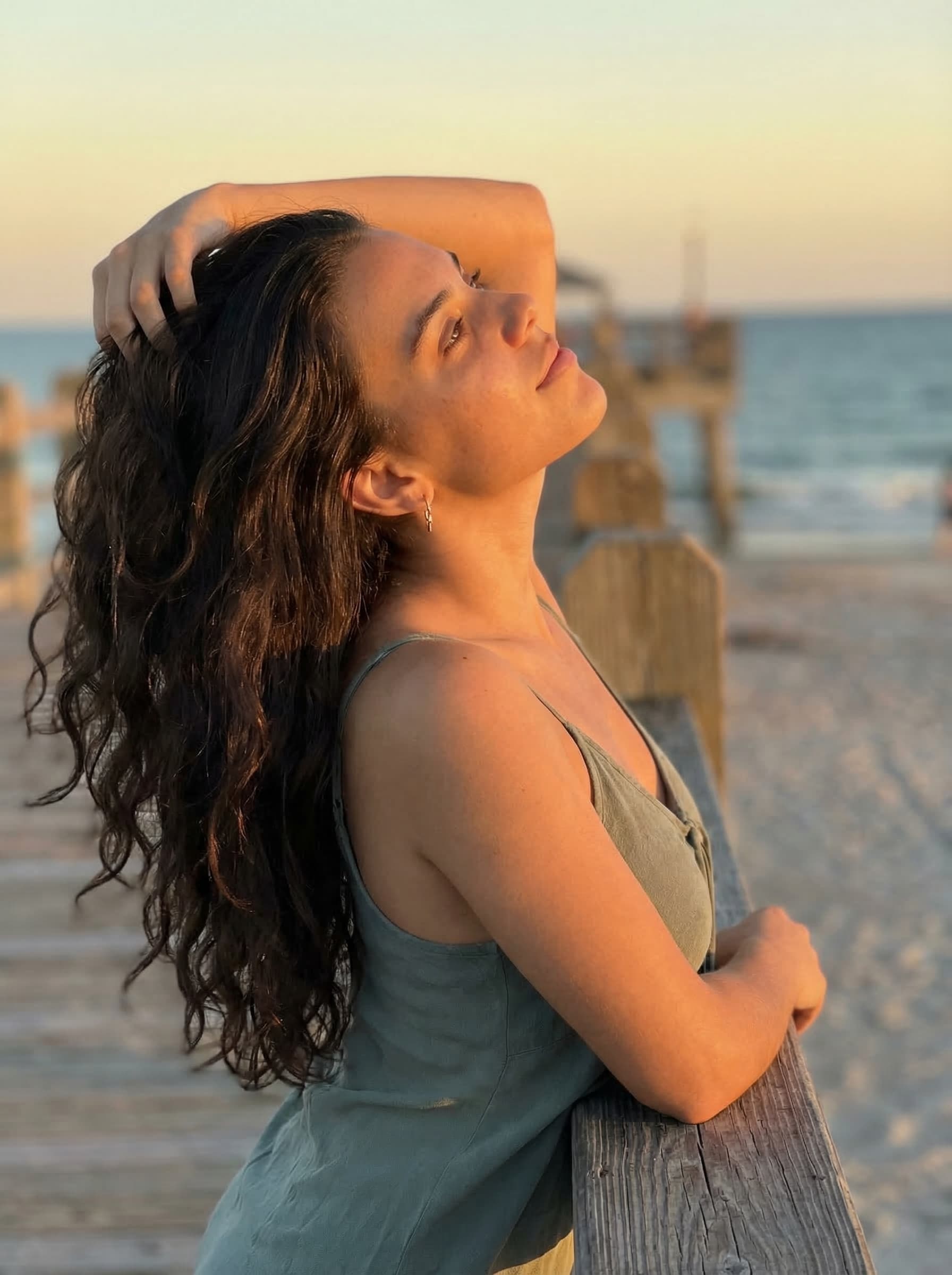 Sydney at the pier during golden hour, wearing a sage green top